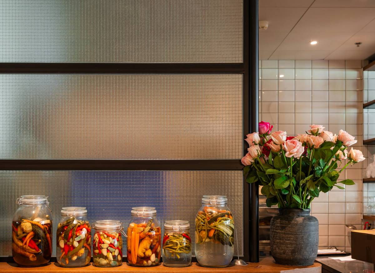 A tidy refrigerator stocked with colorful fruits and vegetables stored in reusable silicone food storage bags, showcasing sustainable food practices at home